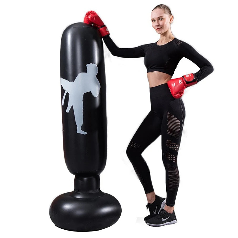 Mulher usando luvas vermelhas ao lado de saco de pancadas inflável para artes marciais preto