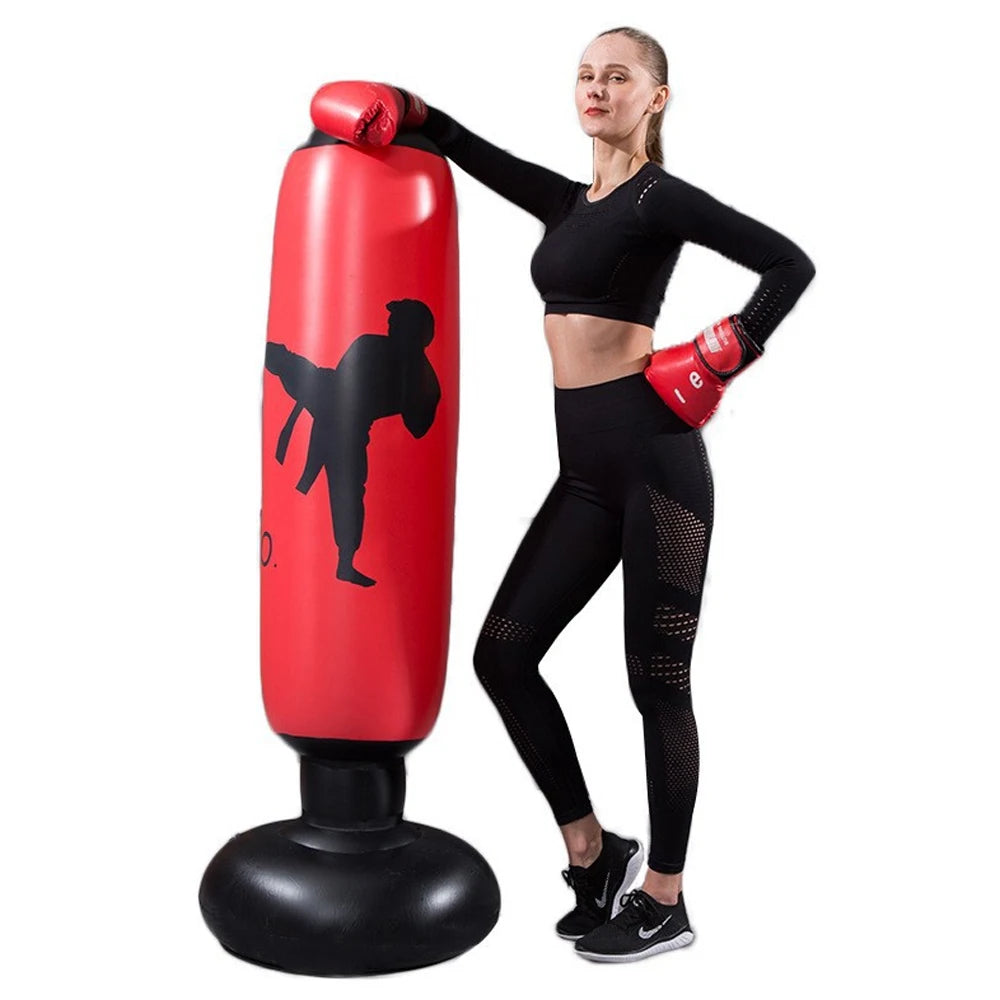 Mulher usando roupas de treino ao lado de saco de pancadas inflável para artes marciais vermelho